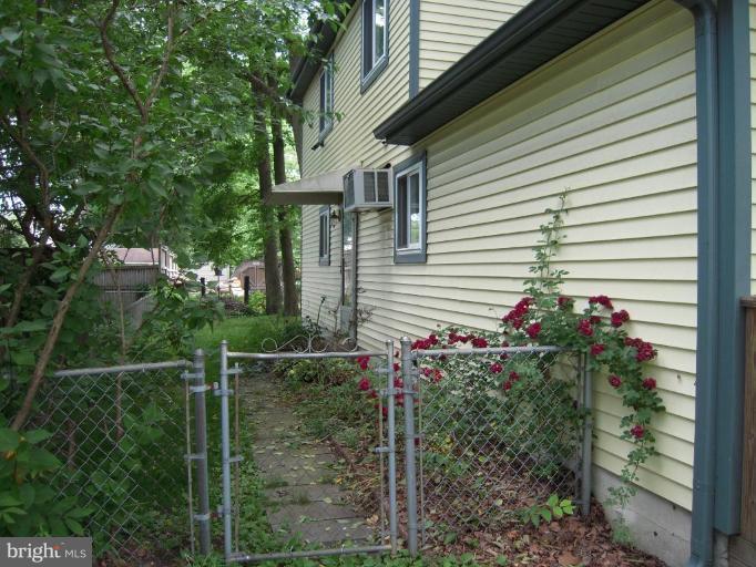 313 Londontown Road Edgewater, MD 21037 - Photo 13 of 25 a small white house with a flower garden and potted plants