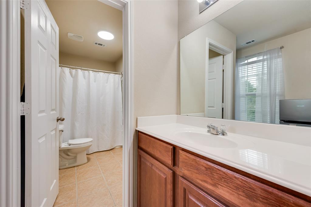 4521 Indian Paint Way Denton, TX 76208 - Photo 31 of 36 a bathroom with a double vanity sink toilet and a mirror