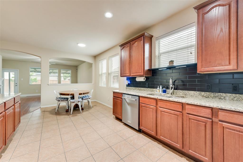 4521 Indian Paint Way Denton, TX 76208 - Photo 7 of 36 a kitchen with stainless steel appliances granite countertop sink window and white cabinets