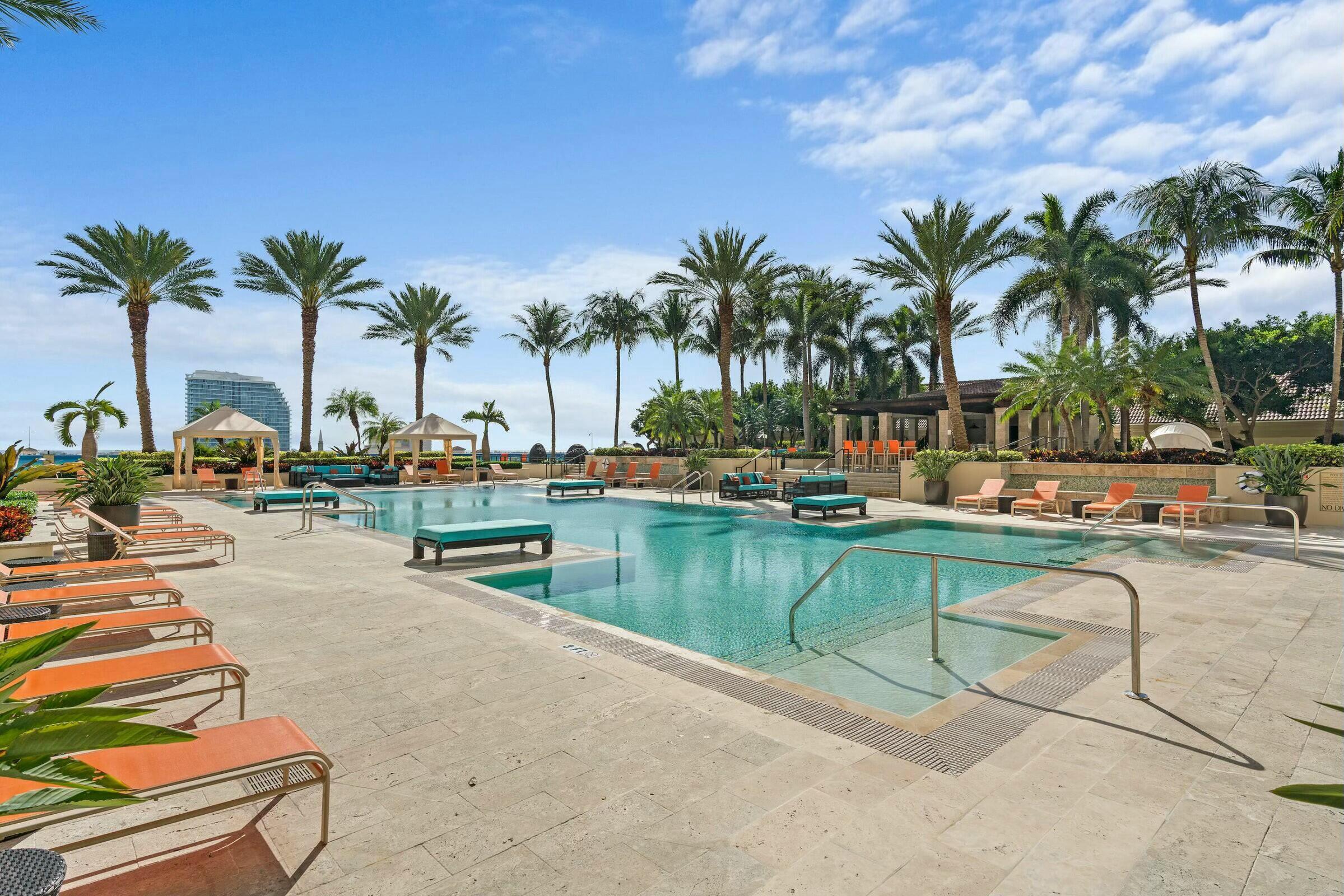 550 Okeechobee Boulevard, Unit 1401 West Palm Beach, FL 33401 - Photo 29 of 46 a row of palm trees and swimming pool in the backyard of a house