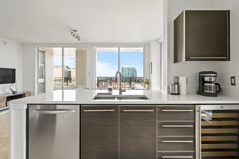 a kitchen with stainless steel appliances granite countertop a sink and a refrigerator