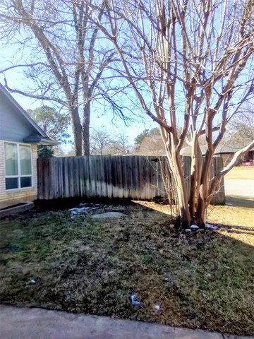a view of a yard with wooden fence