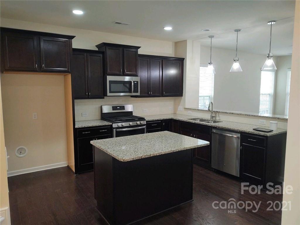 5077 Waterloo Drive Tega Cay, SC 29708 - Photo 3 of 15 a kitchen with kitchen island granite countertop stainless steel appliances a sink stove and refrigerator