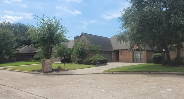 a view of a house with a garden and trees