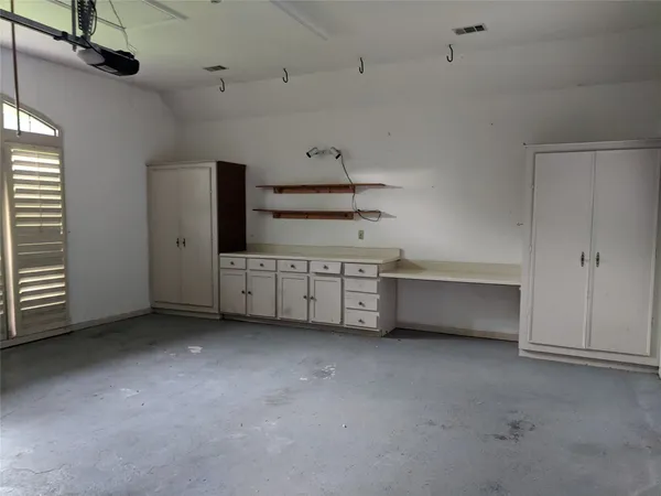 a view of an empty room with a cabinet and mirrors