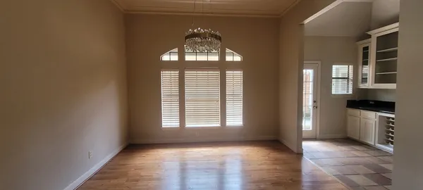 a view of a hallway with windows and chandelier