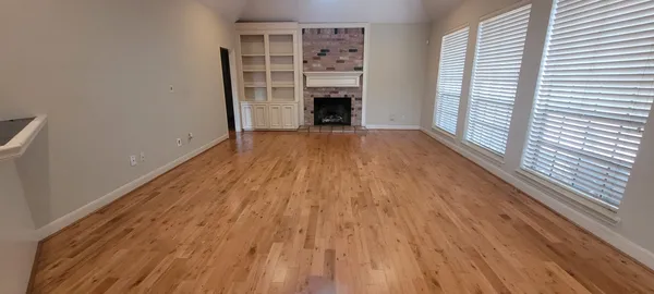 wooden floor in a room next to a window