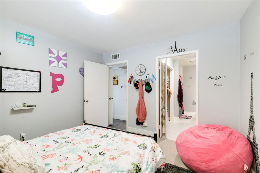 4347 Dickason Avenue, Unit 111 Dallas, TX 75219 - Photo 18 of 37 a bedroom with a bed and a mirror