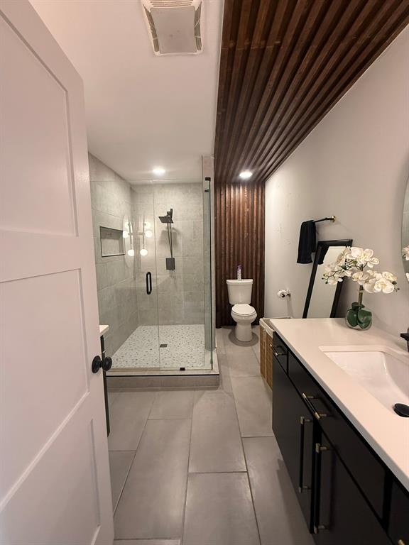4347 Dickason Avenue, Unit 111 Dallas, TX 75219 - Photo 31 of 37 Bathroom with vanity, a shower stall, and light tile patterned floors