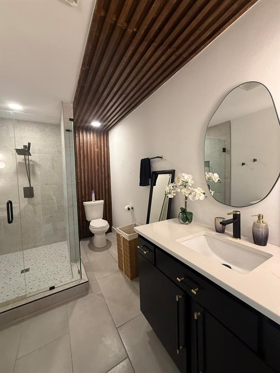 4347 Dickason Avenue, Unit 111 Dallas, TX 75219 - Photo 34 of 37 Bathroom featuring vanity, a stall shower, and light tile patterned flooring