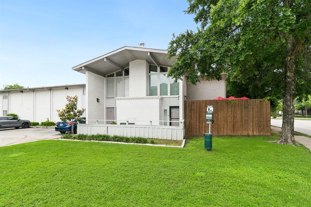 4347 Dickason Avenue, Unit 111 Dallas, TX 75219 - Photo 5 of 37 a front view of a house with a yard and a tree
