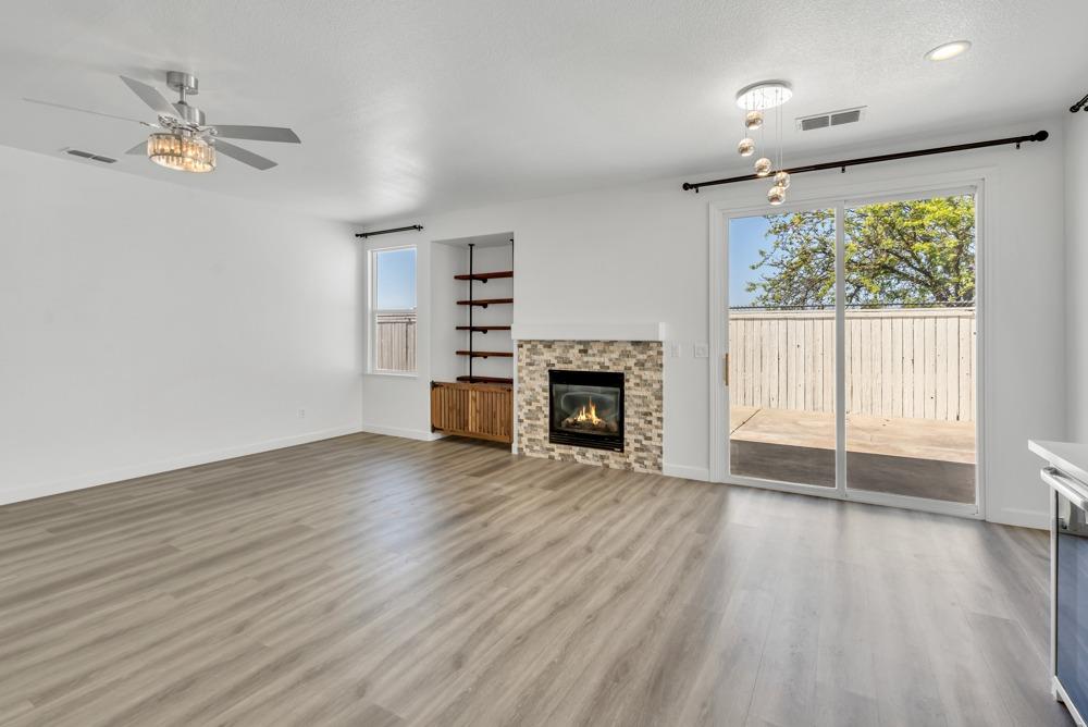 6217 Jefjen Way Elk Grove, CA 95757 - Photo 11 of 41 an empty room with wooden floor fireplace and windows