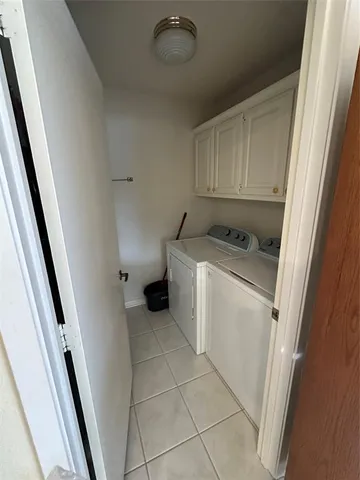 a utility room with cabinets washer and dryer