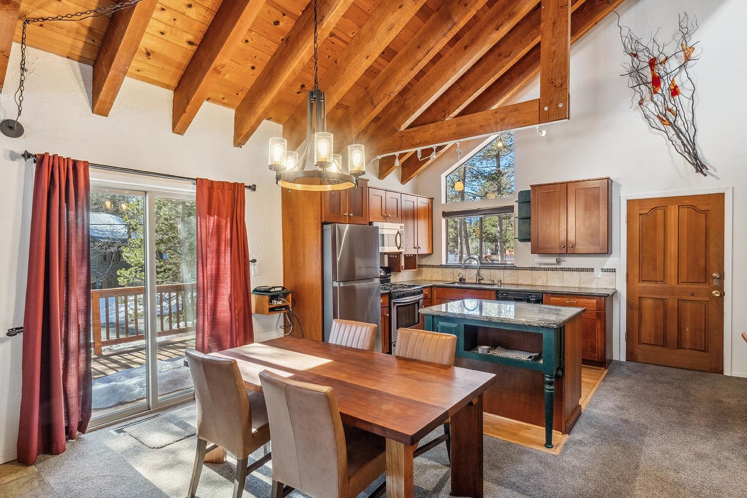 390 Forest Glen Road Olympic Valley, CA 96146 - Photo 2 of 25 a kitchen with stainless steel appliances granite countertop a sink a stove a refrigerator a dining table and chairs with wooden floor