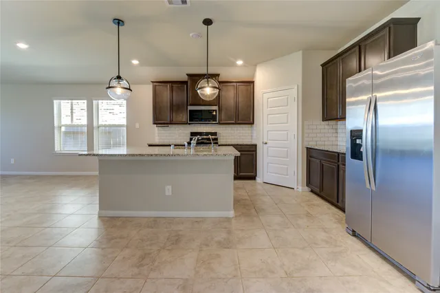 a kitchen with stainless steel appliances granite countertop a sink a stove and a refrigerator