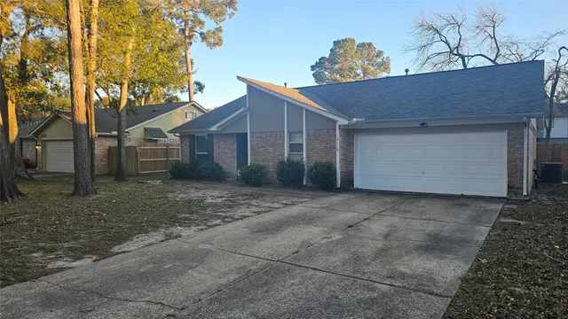 a view of a house with a yard and large tree