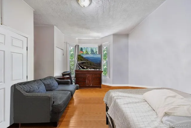 a bedroom with bed couch and a window