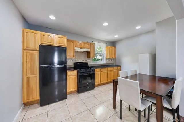 a kitchen with a refrigerator a stove and a dining table