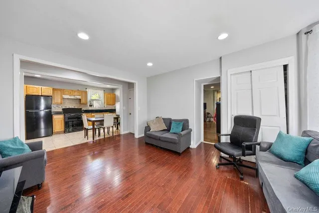 a living room with furniture and a flat screen tv with wooden floor