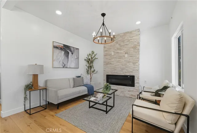 a living room with furniture chandelier and a fireplace
