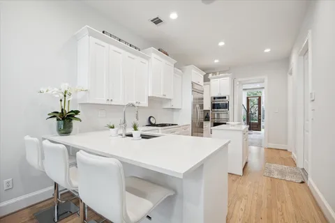 a kitchen with kitchen island a stove a table and chairs in it
