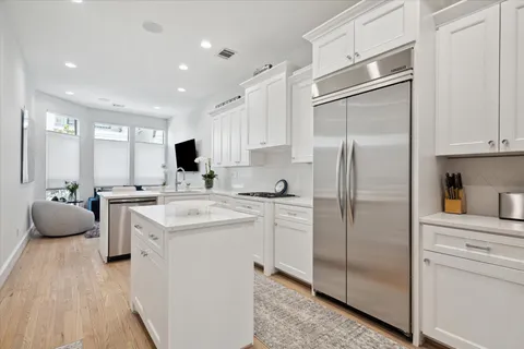 a kitchen with a refrigerator sink and white cabinets