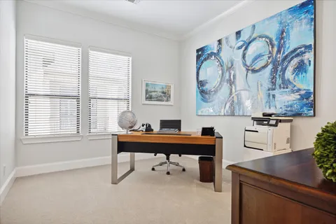 a workspace with furniture and paintings on the wall