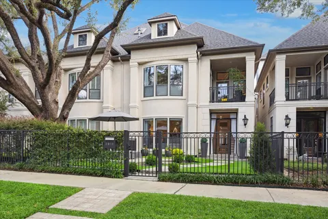 a view of a brick house with a yard and plants