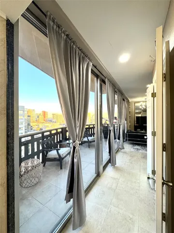 a view of a livingroom with furniture and floor to ceiling window
