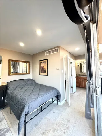 a spacious bedroom with a bed and a large mirror