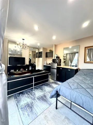 a living room with kitchen furniture and a flat screen tv
