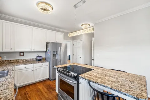 a view of a hallway with wooden floor and cabinet