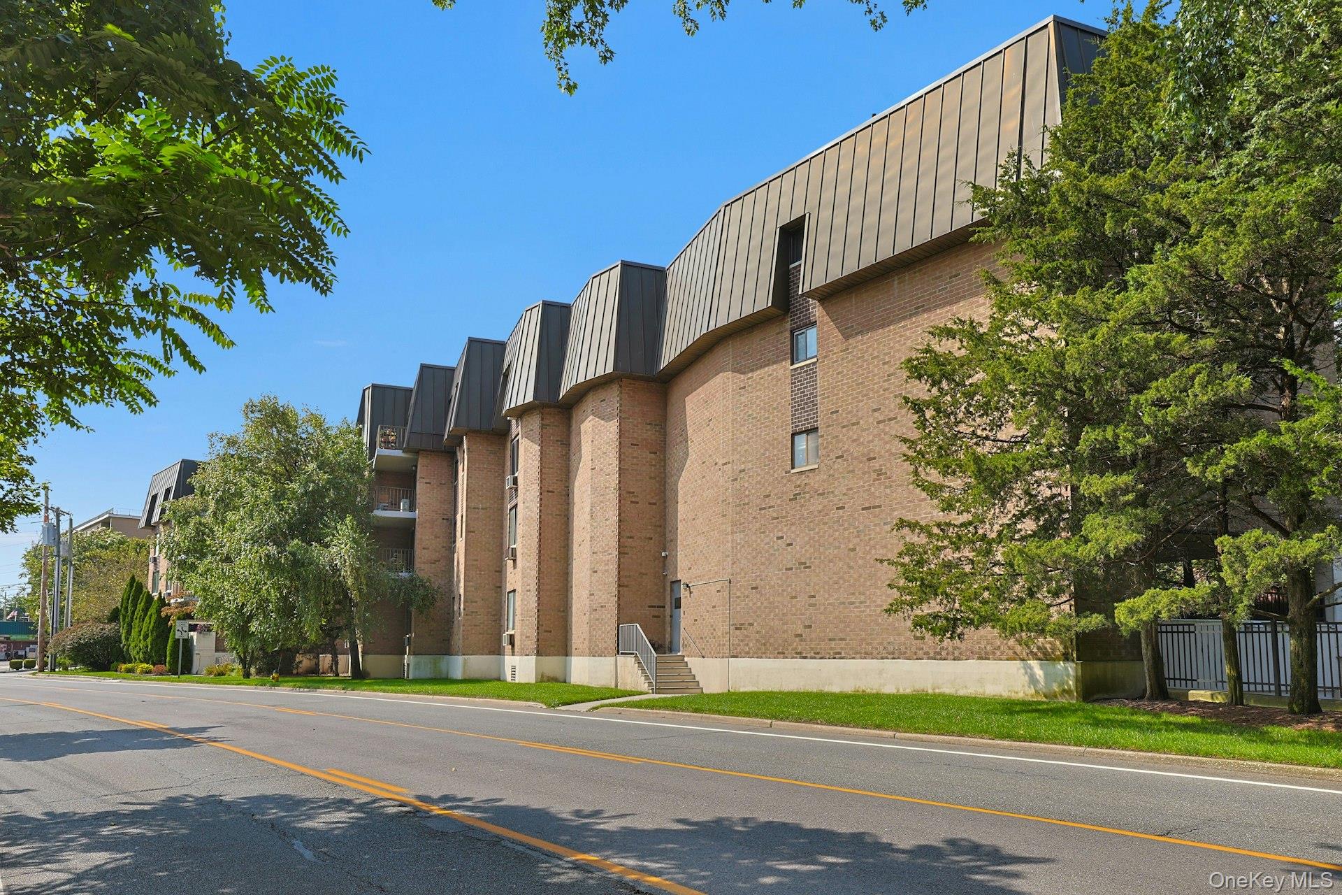 560 Halstead Avenue, Unit 2E Harrison, NY 10528 - Photo 3 of 28 a view of a tall building next to a road