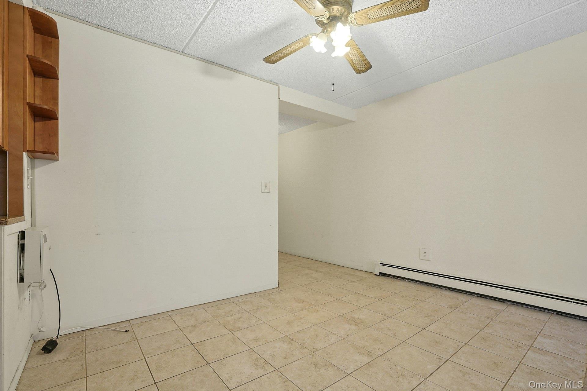 560 Halstead Avenue, Unit 2E Harrison, NY 10528 - Photo 7 of 28 an empty room with a ceiling fan and carpet