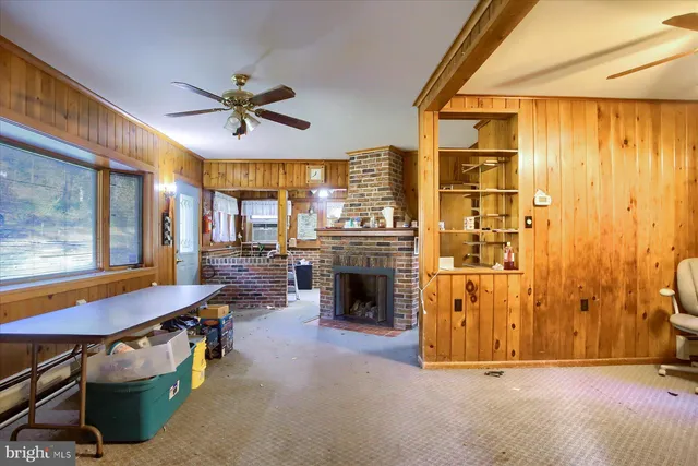 a living room with a table chairs and a refrigerator