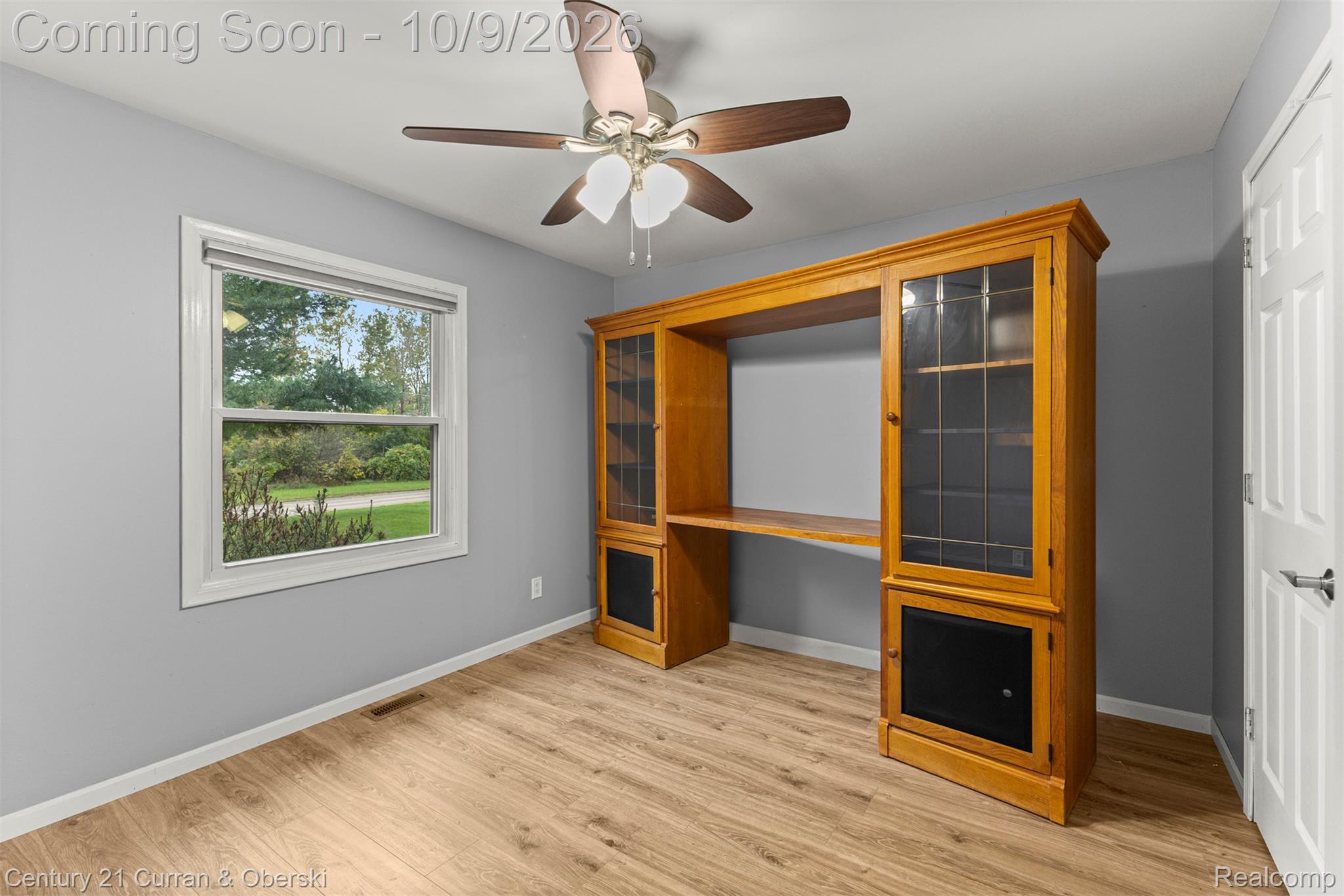43040 Willis Road Belleville, MI 48111 - Photo 27 of 65 Wood-finish flooring, built-in wooden shelving unit, ceiling fan with integrated lighting, white trim window, and neutral wall paint