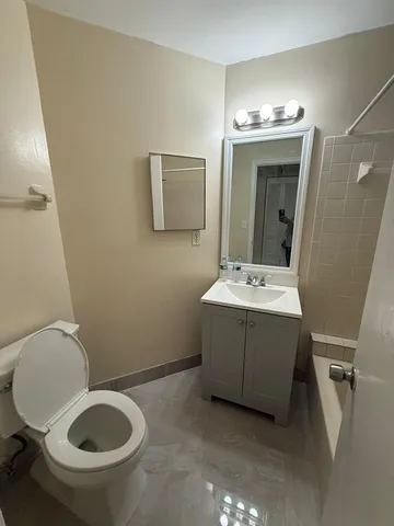 a bathroom with a sink mirror vanity and toilet