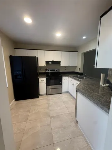 a large kitchen with a stove a refrigerator and a sink