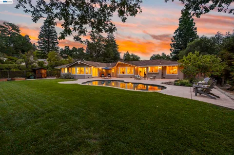 a view of a house with a swimming pool and a yard