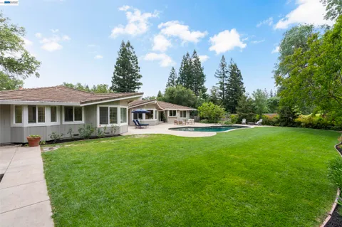 a view of a house with a yard and sitting area