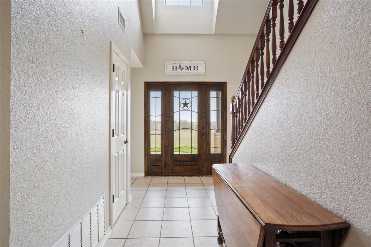 8600 Five Wells Road Rogers, TX 76569 - Photo 4 of 40 Foyer with a textured wall, light tile patterned floors, and a high ceiling