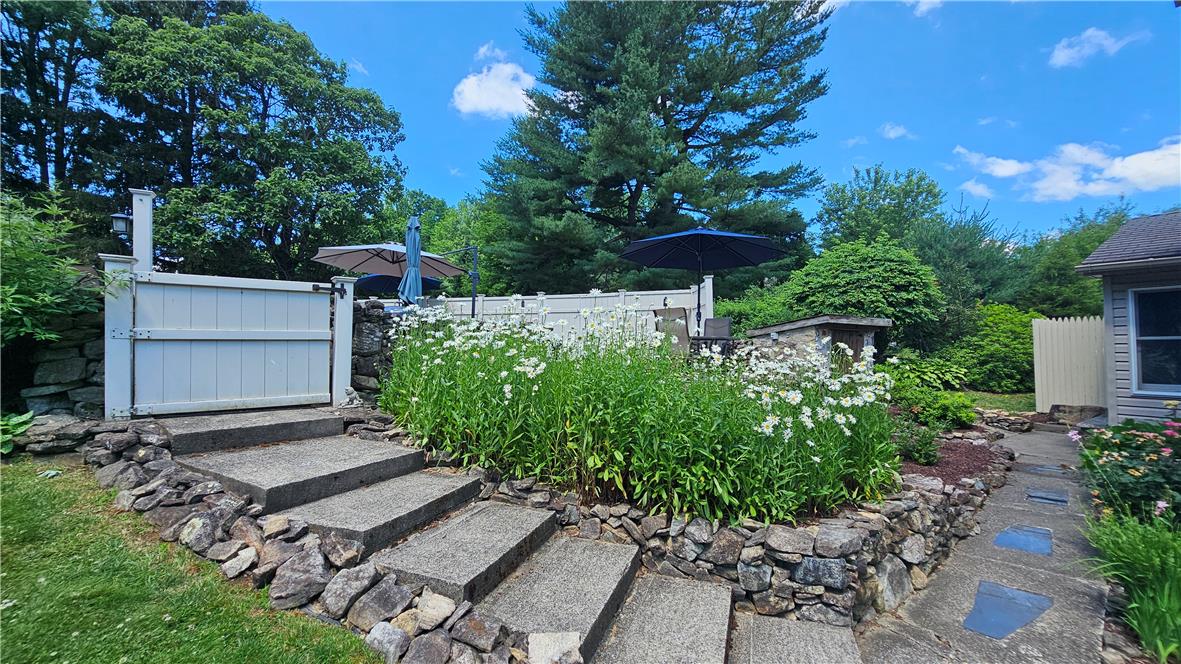 585 Buttermilk Road Hellertown, PA 18055 - Photo 41 of 82 Stone steps lead up to a private patio, framed by lush gardens and mature trees.