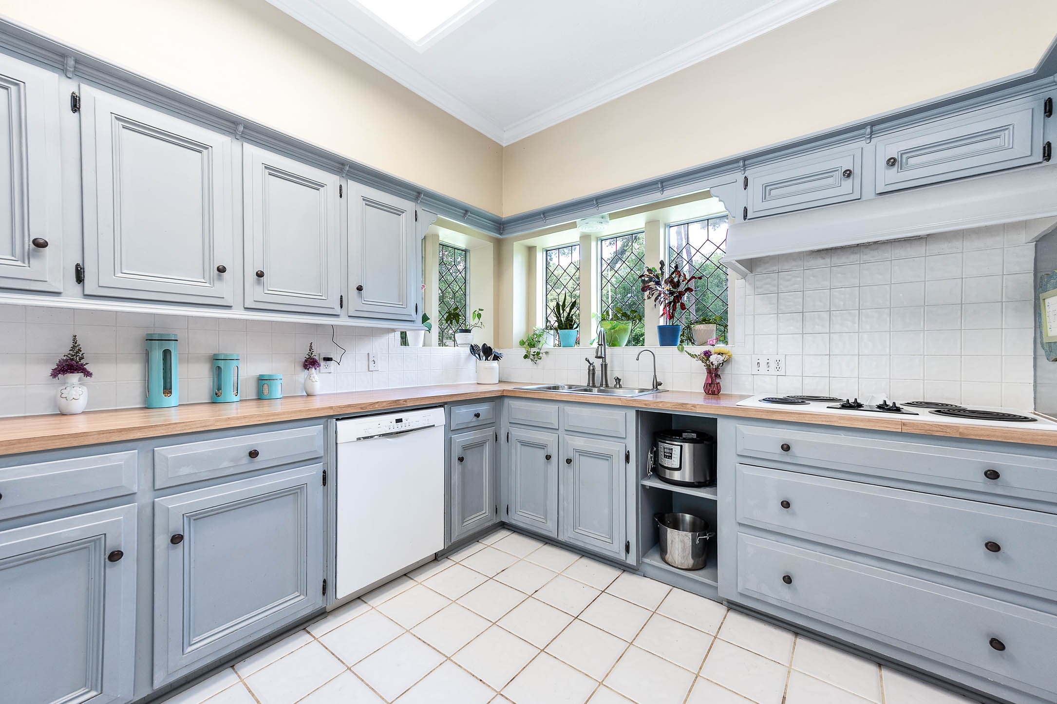 9911 Oxted Lane Spring, TX 77379 - Photo 13 of 39 a kitchen with granite countertop white cabinets and white appliances