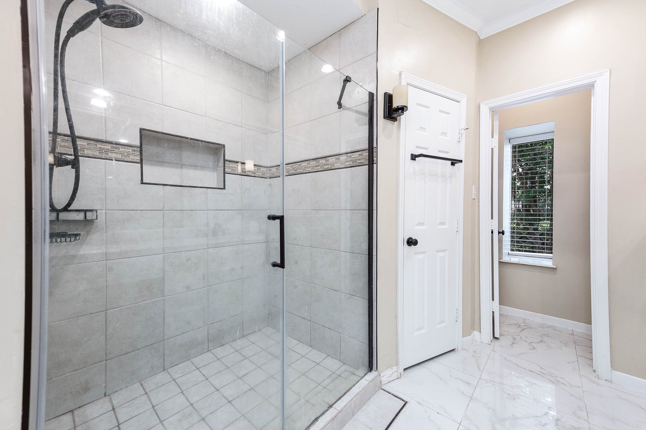 9911 Oxted Lane Spring, TX 77379 - Photo 20 of 39 a bathroom with a glass shower door