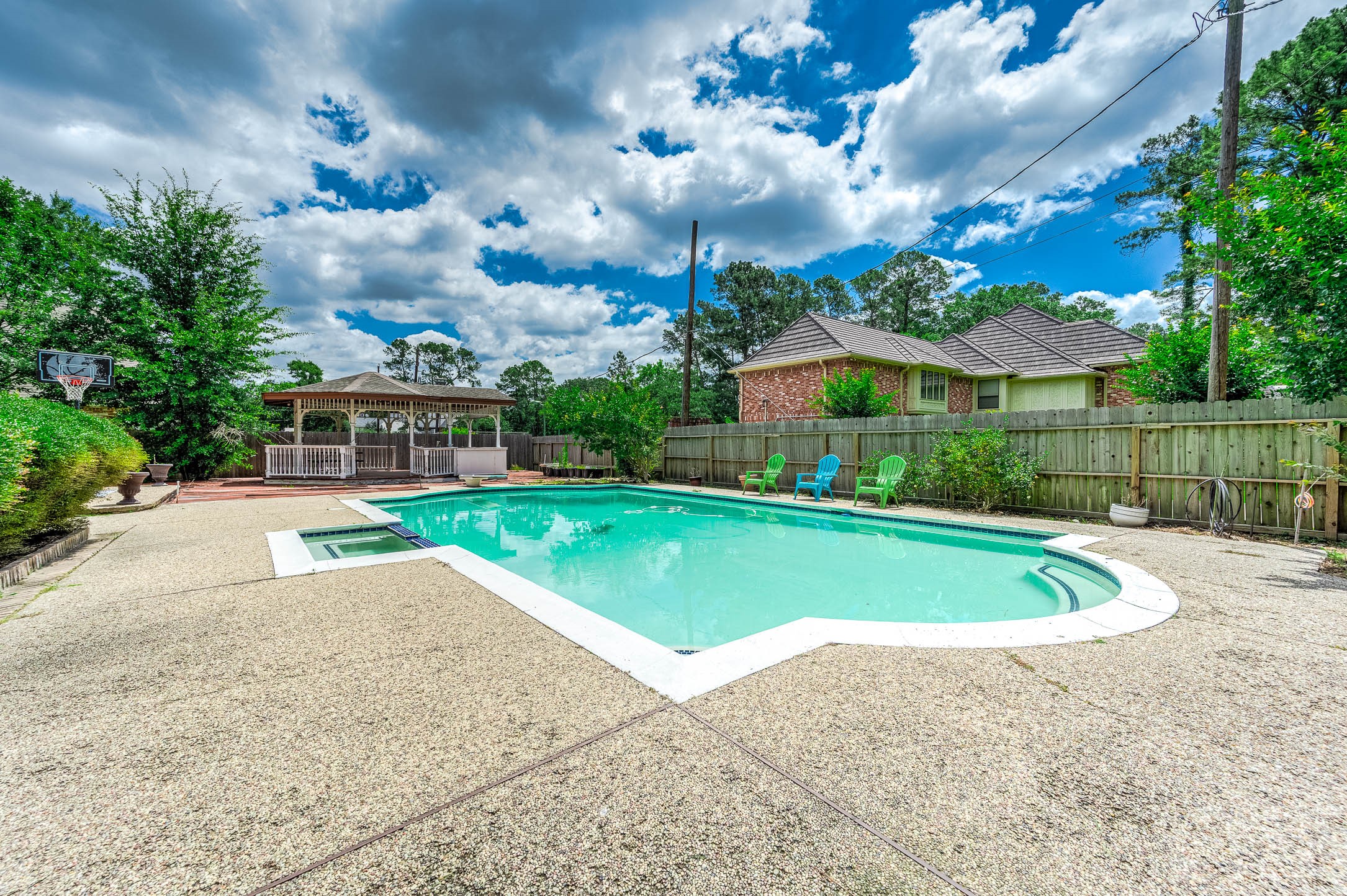9911 Oxted Lane Spring, TX 77379 - Photo 32 of 39 a view of a house with a swimming pool and a yard