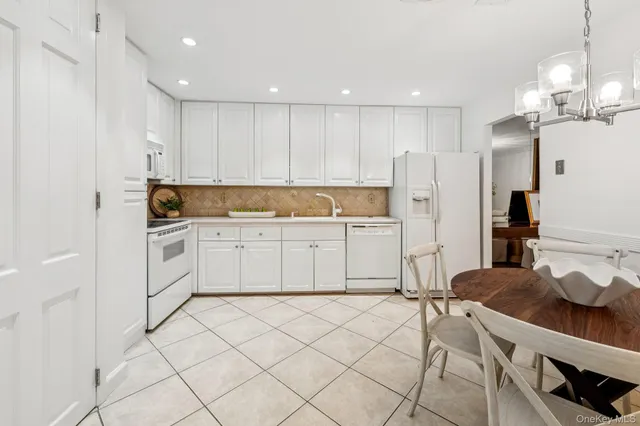 a kitchen with white cabinets and white appliances