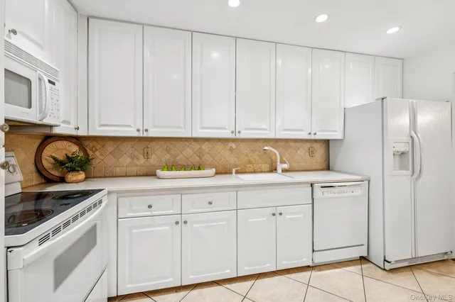 a kitchen with granite countertop white cabinets and stainless steel appliances