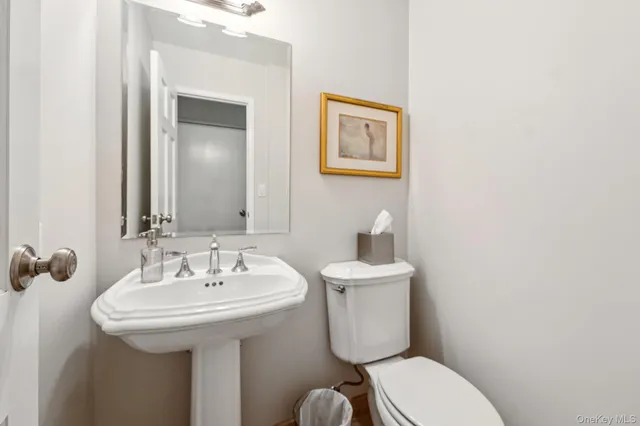 a bathroom with a toilet sink and mirror