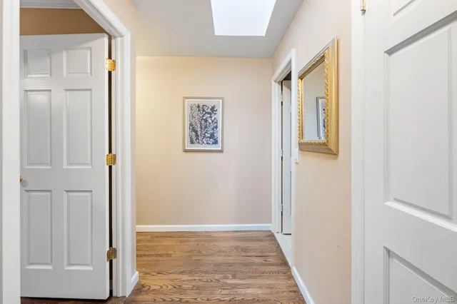 a view of a hallway with wooden floor and a cabinet
