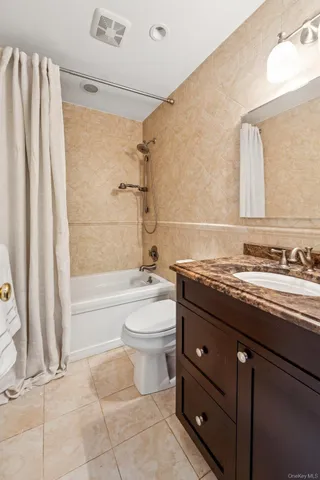 a bathroom with a granite countertop sink a toilet and bathtub